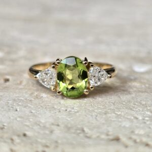 Anel em Ouro Amarelo 18K com Peridoto Oval e Diamantes Trilhão